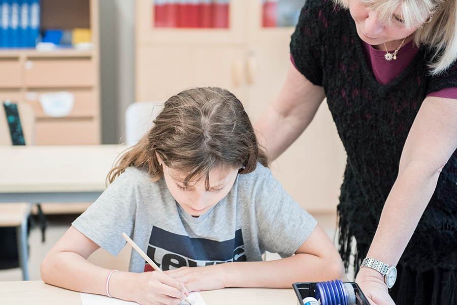 Barn får hjälp av lärare i klassrum 