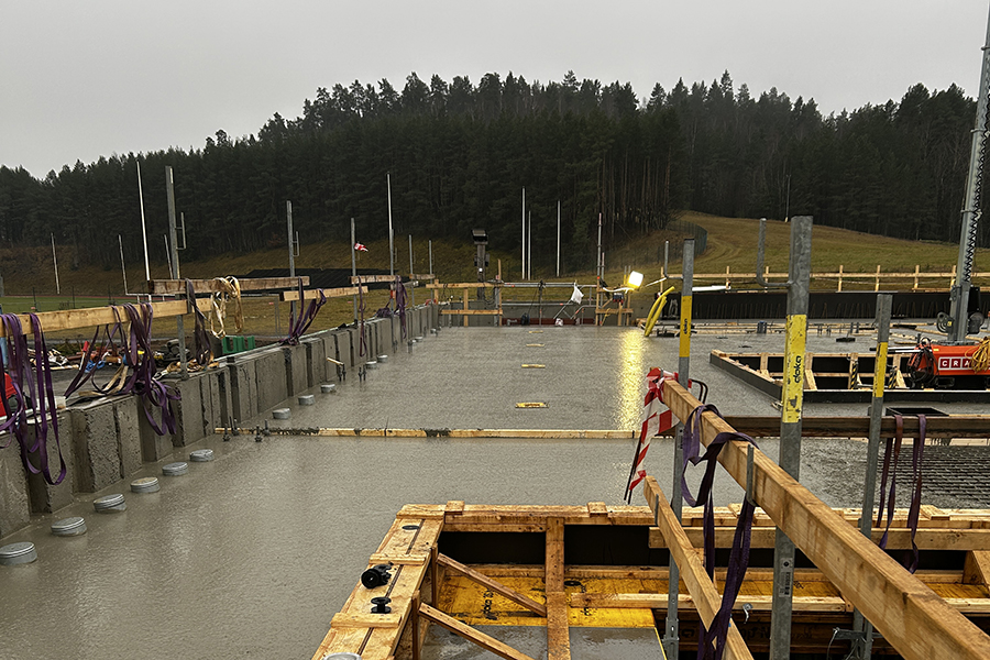 En byggarbetsplats med en grå betongplatta med trästaket runt om.