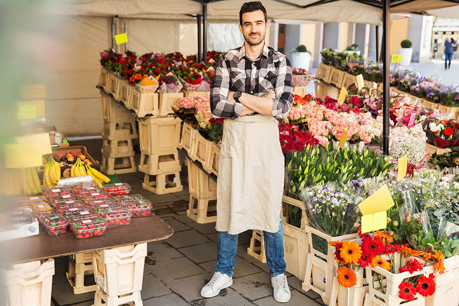 Man som står vid blomsterhandel.