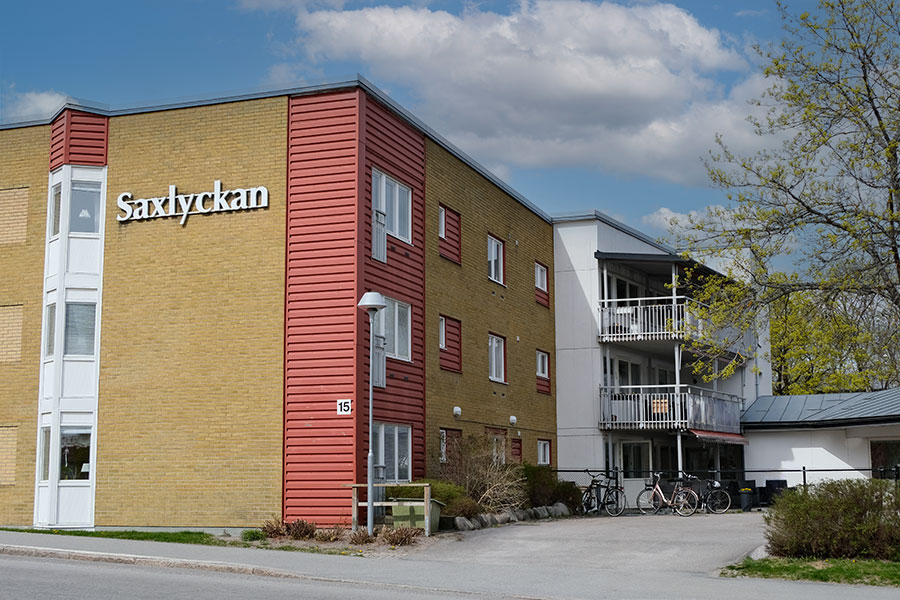 "Saxlyckan" syns tydligt på en gul byggnad med röda detaljer.