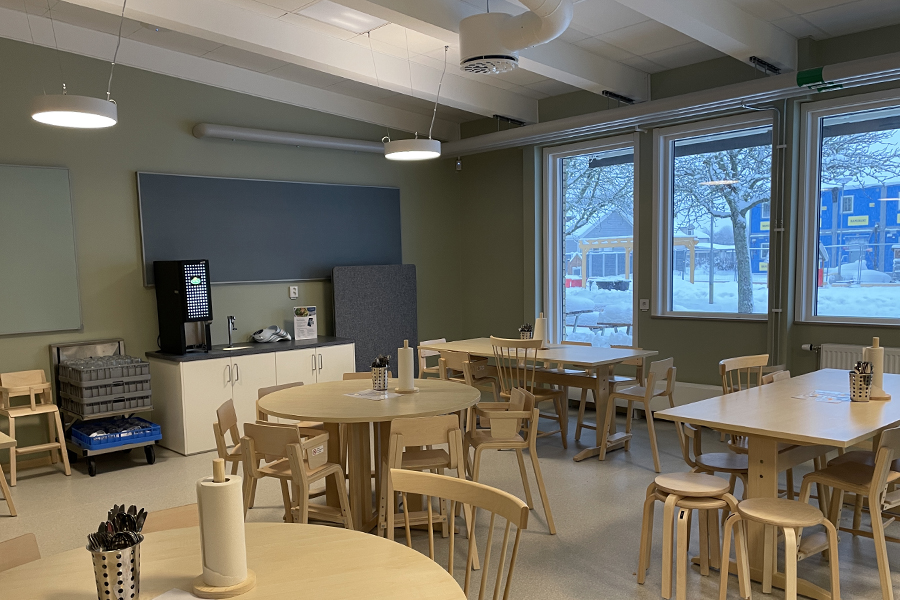 Ett rum med runda bord och stolar.