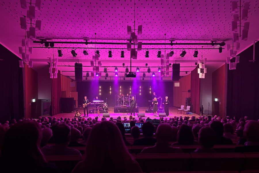 en scen där en föreställning pågår, upplyst i lila ljus