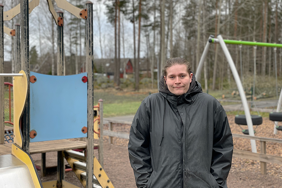 Porträtt kille lekplats i bakgrunden