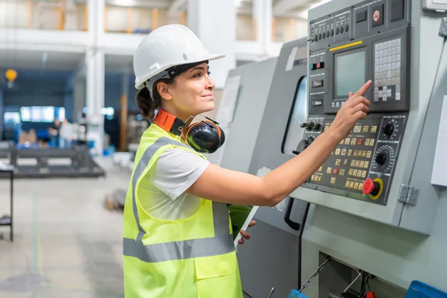Kvinna trycker på knappar på en modern CNC-maskin