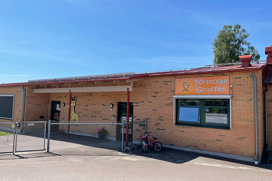 Giraffen förskola. En röd tegelbyggnad med en stor orange skylt som säger förskolan giraffen. 