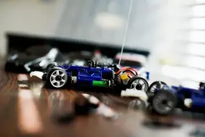 Ett tennisrack i närbild. Framför ligger en tennnisboll. 