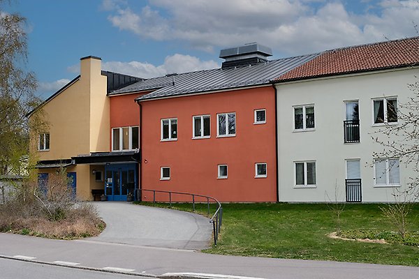 En byggnad med tre sektioner i gul, orange och vit.