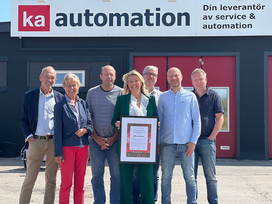 Personer står framför KA Automations byggnad med priset för Årets Företag