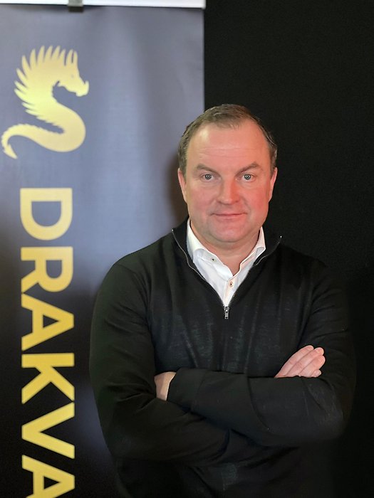 Joakim Ringman med armarna i kors framför loggan "Drakvalvet"
